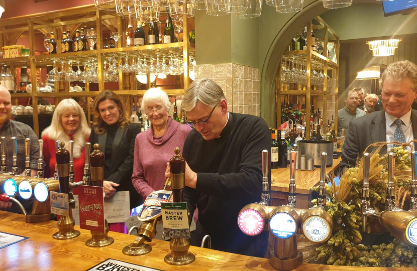 The Very Reverend Philip Hesketh pulling the first pint